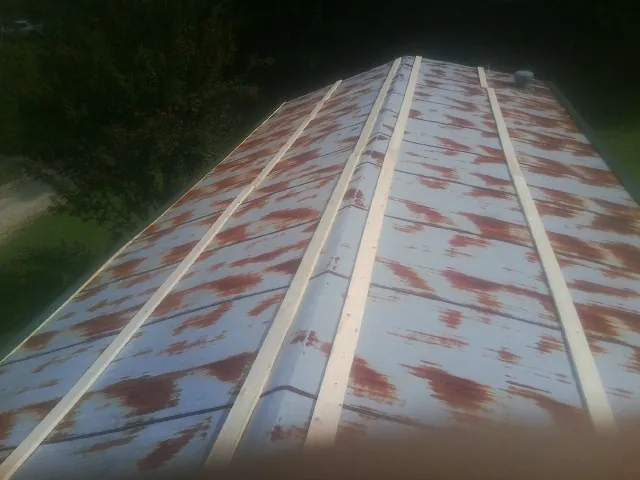 Rusted metal roof panels with new wood purlins before replacement — Storm Damage Roof Repair in Lonaconing by Roofing Brothers