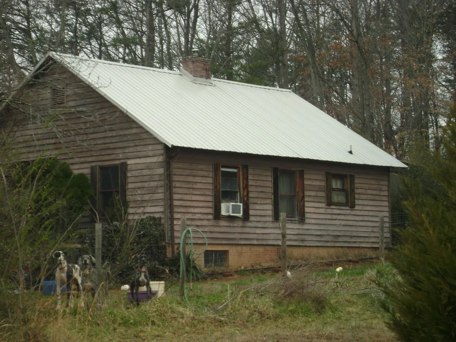 White metal roof on an old wood sided farmhouse, from a Metal Roof Installation job in Lonaconing